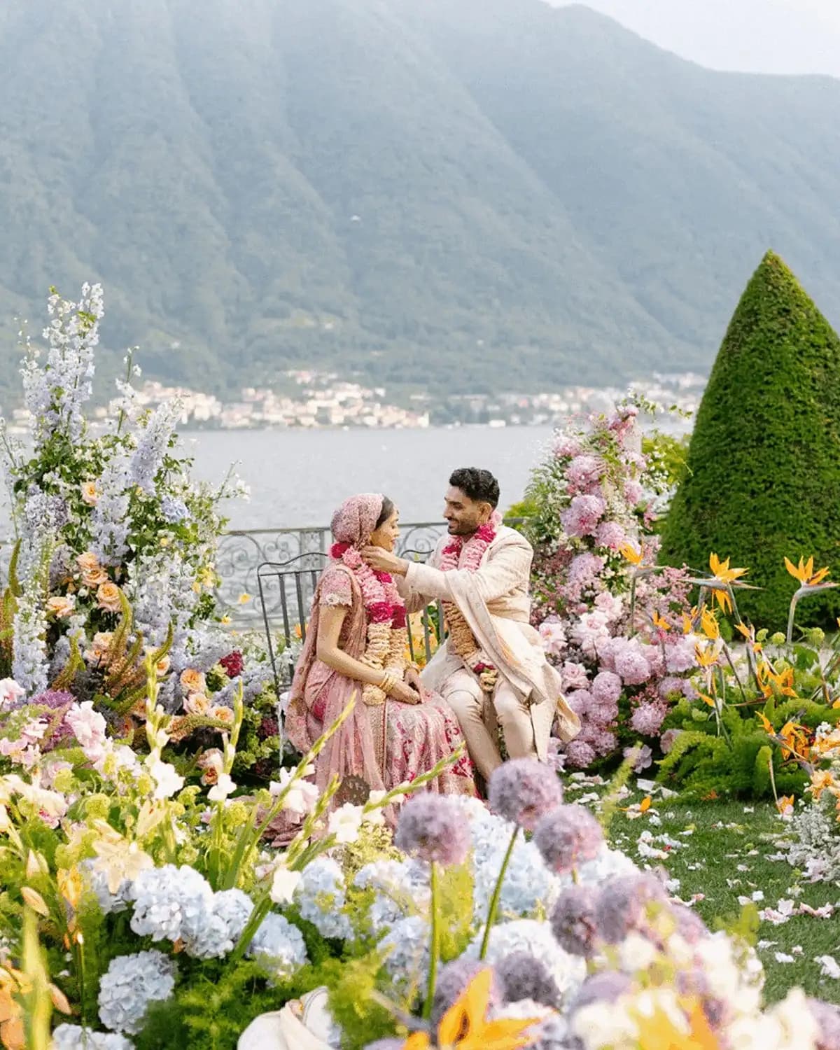 Lake Como villa wedding at sunset, mandap erected on terrace overlooking the water, bougainvillea and brass detailing