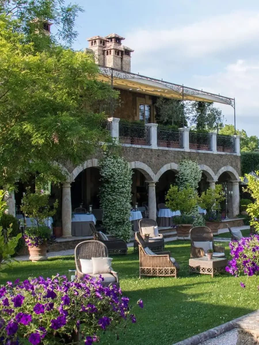 Borgo Santo Pietro vineyard courtyard at golden hour, olive trees and stone walls