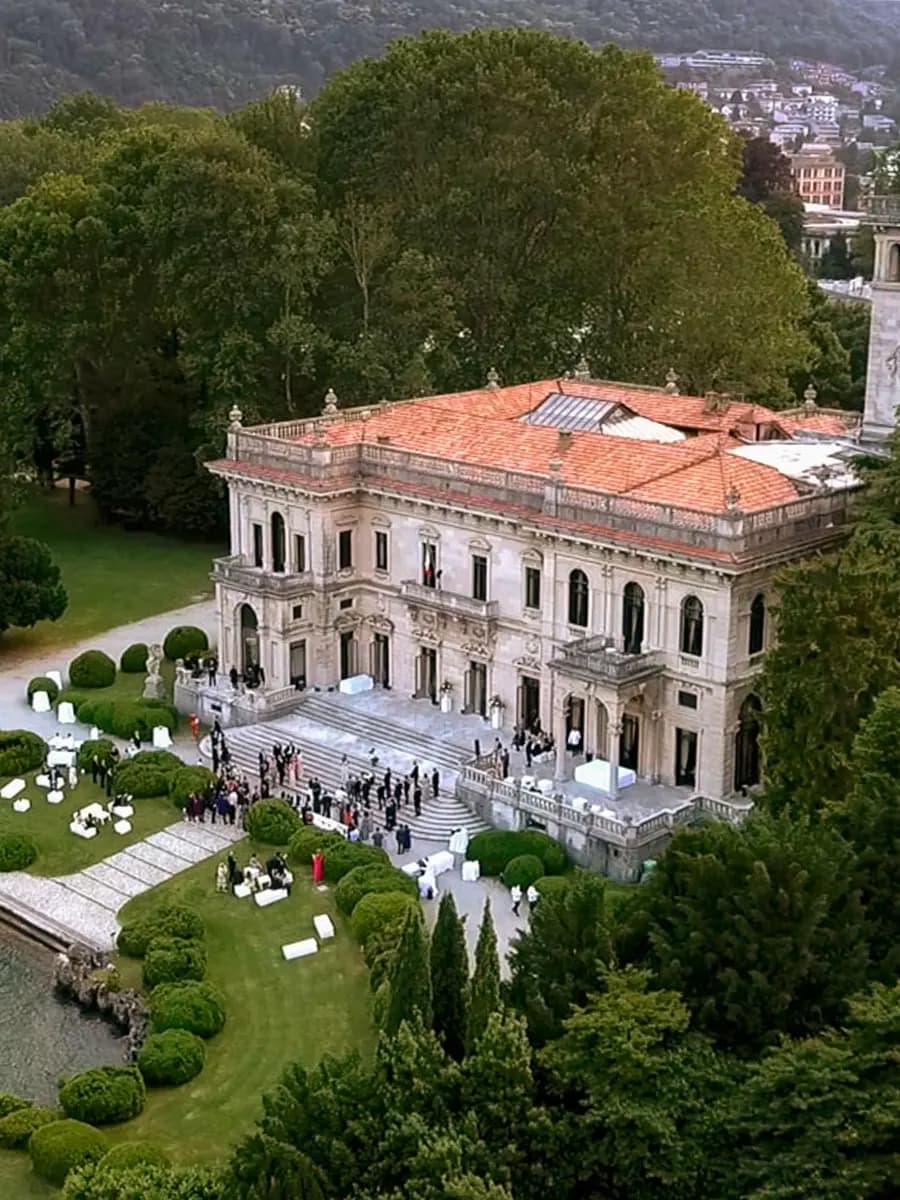 Villa Erba lawn at golden hour, Lake Como behind, classical pavilion ahead