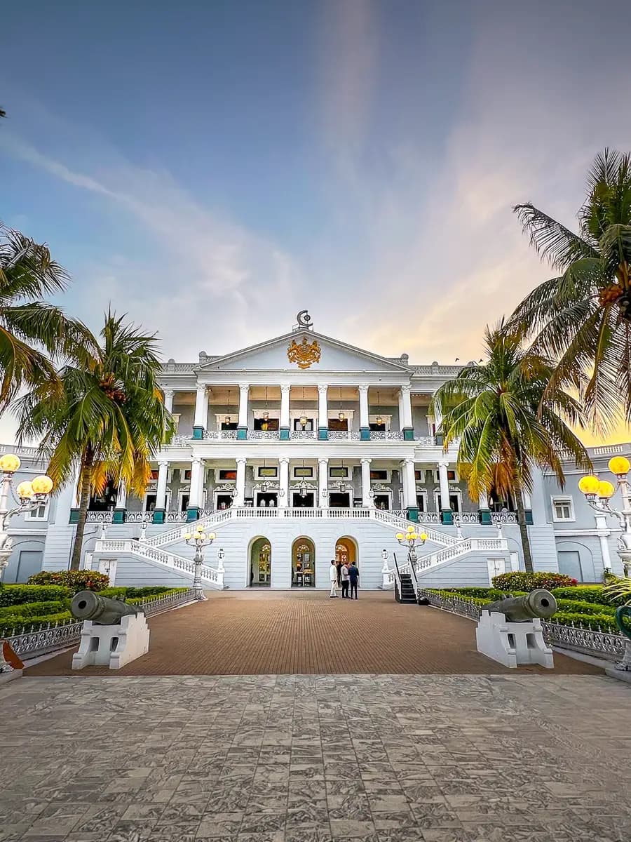 Taj Falaknuma Palace at dusk, marble facade lit warm against twilight sky