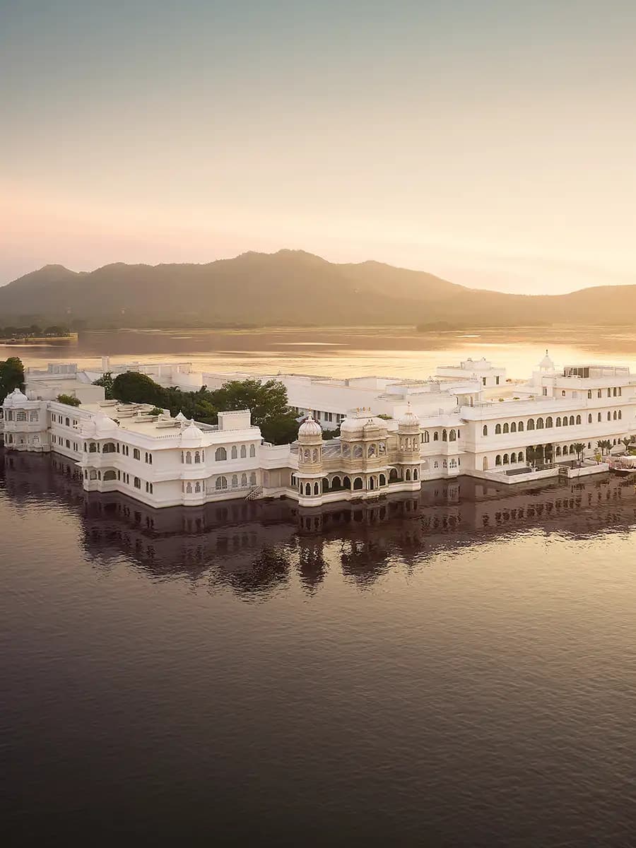 Taj Lake Palace floating on Lake Pichola at twilight, white marble against still water