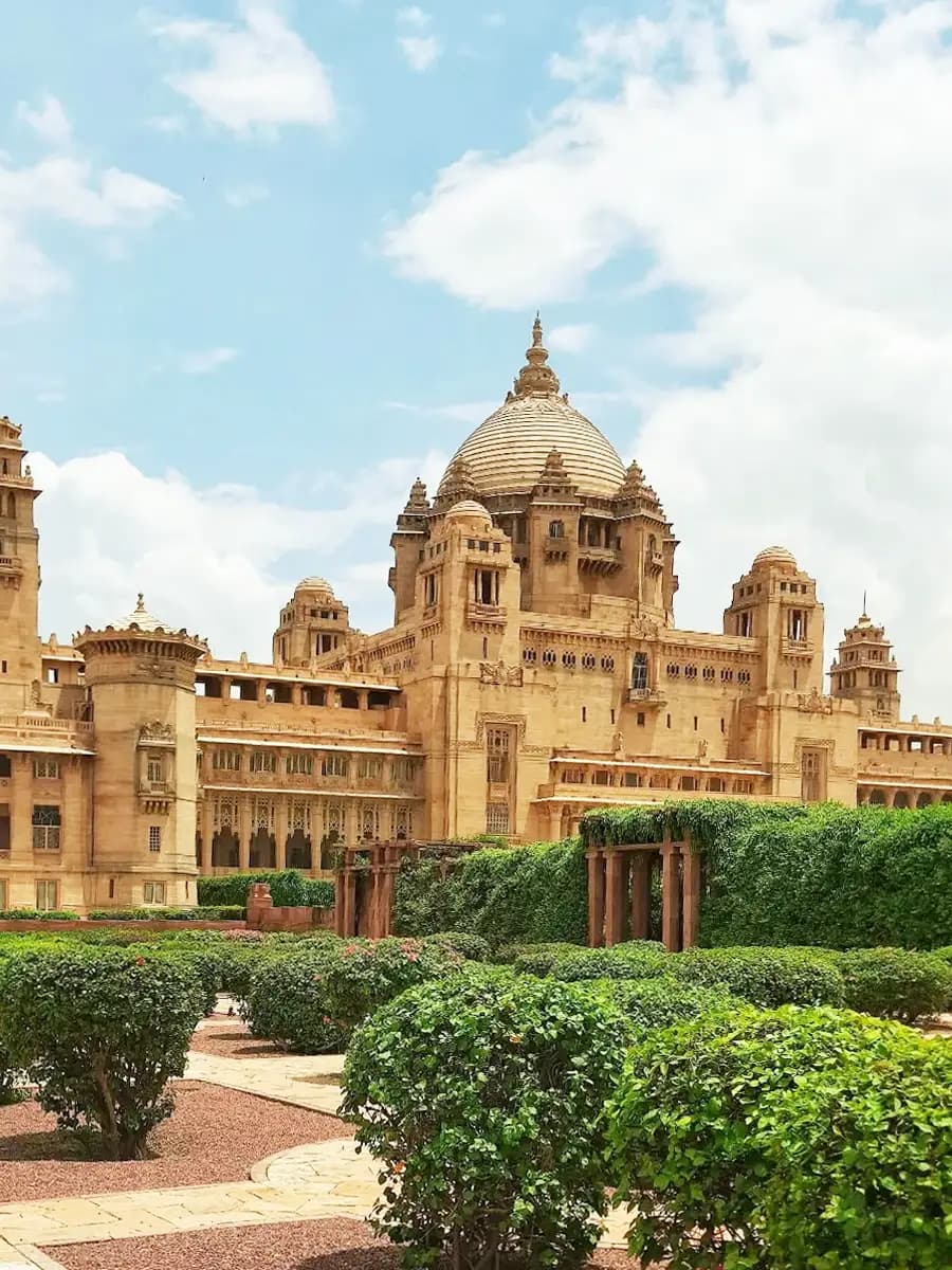 Umaid Bhawan Palace courtyard at golden hour, sandstone arches and marigold festoons